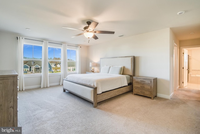 carpeted bedroom with ensuite bath and ceiling fan