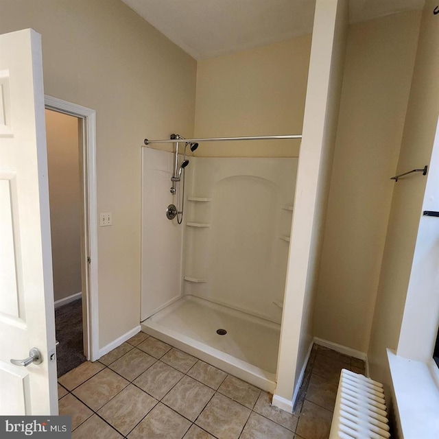 bathroom featuring tile patterned floors, a shower, and radiator