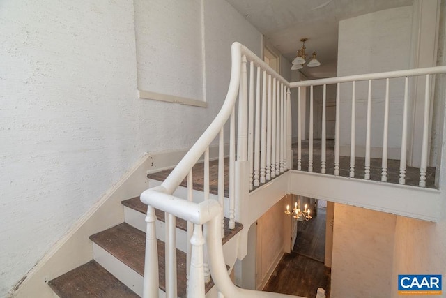 stairs featuring a chandelier