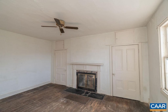 unfurnished living room with ceiling fan and dark wood-type flooring