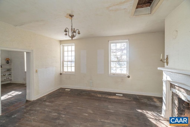 unfurnished dining area with dark wood-type flooring and an inviting chandelier