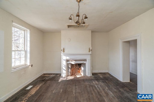 unfurnished living room with dark wood-type flooring and a notable chandelier