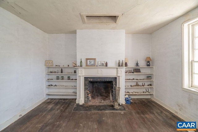 unfurnished living room featuring a wealth of natural light and dark hardwood / wood-style floors