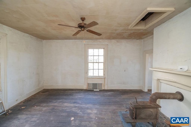 unfurnished living room with ceiling fan, dark hardwood / wood-style floors, and a wood stove