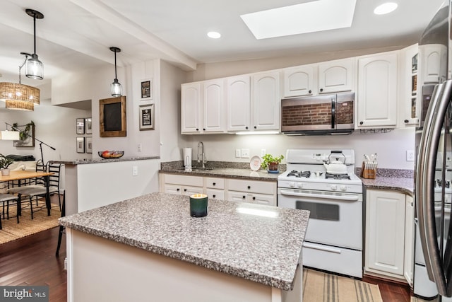 kitchen featuring white cabinetry, dark wood-type flooring, a kitchen island, and stainless steel appliances