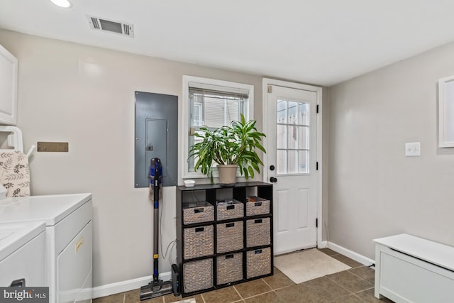 clothes washing area with washing machine and clothes dryer, electric panel, and dark tile patterned floors