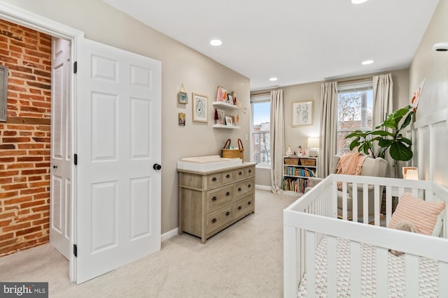 carpeted bedroom featuring a nursery area