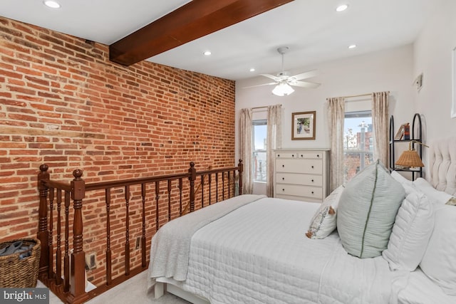 bedroom with beam ceiling, ceiling fan, carpet floors, and brick wall