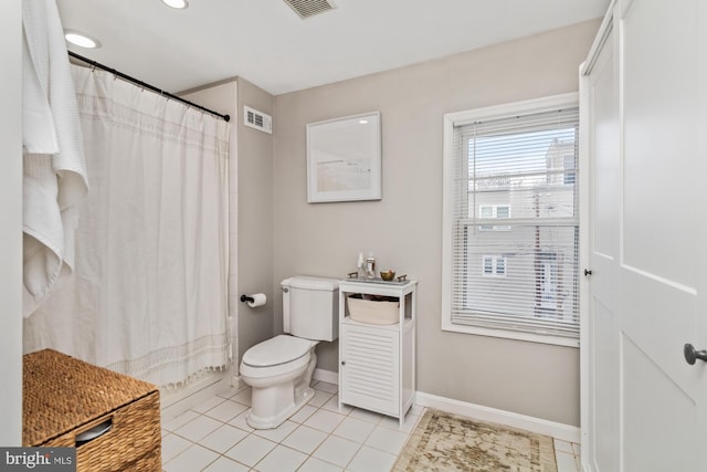 bathroom with tile patterned flooring, shower / bath combo, and toilet