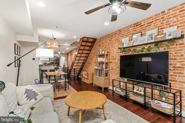 living room with ceiling fan, dark wood-type flooring, and brick wall