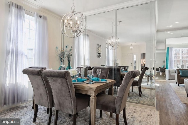 dining room featuring hardwood / wood-style flooring, ornamental molding, and an inviting chandelier