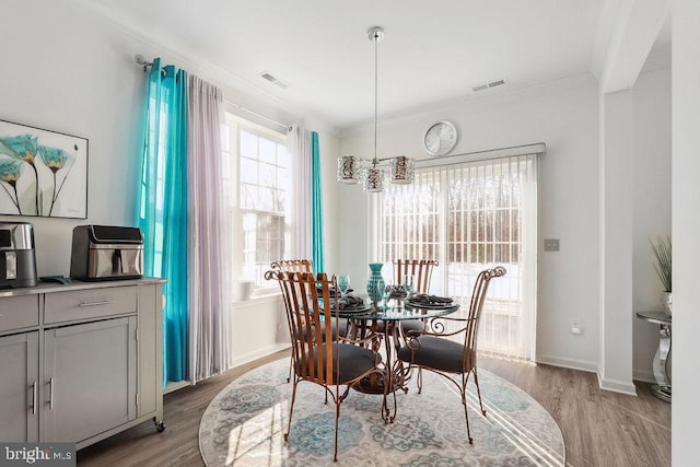 dining room featuring ornamental molding and light hardwood / wood-style flooring