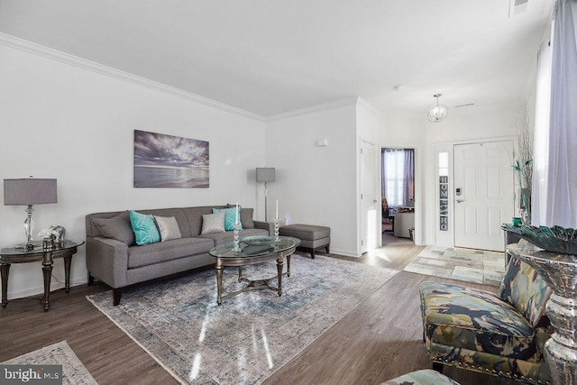 living room featuring crown molding, hardwood / wood-style flooring, and an inviting chandelier