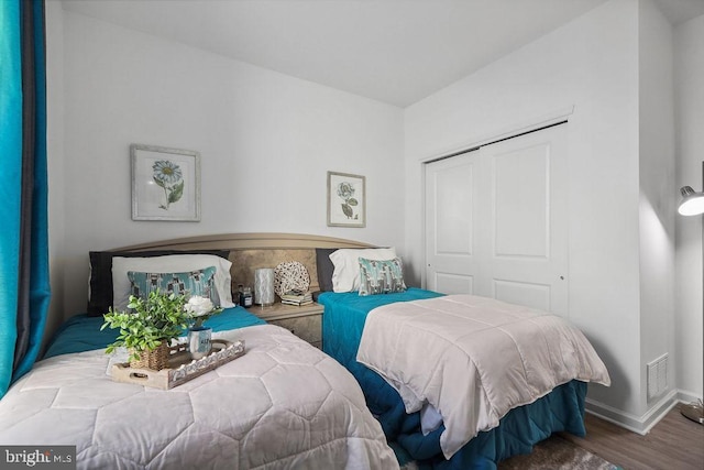 bedroom with hardwood / wood-style floors and a closet