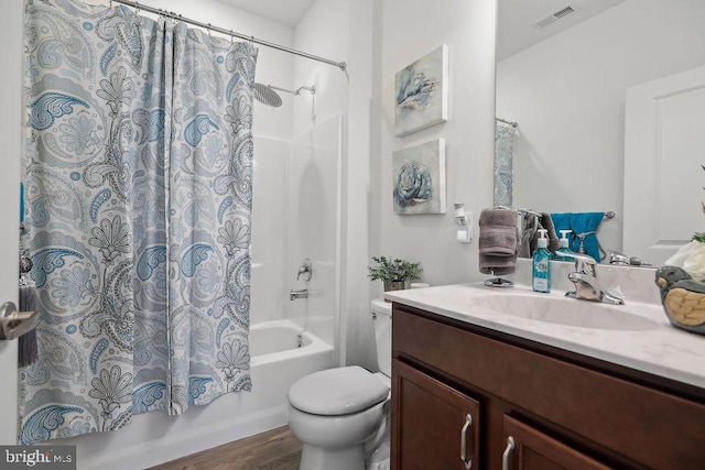 full bathroom featuring wood-type flooring, toilet, shower / bath combo with shower curtain, and vanity