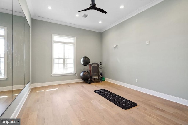 exercise room featuring ceiling fan, ornamental molding, and light hardwood / wood-style floors