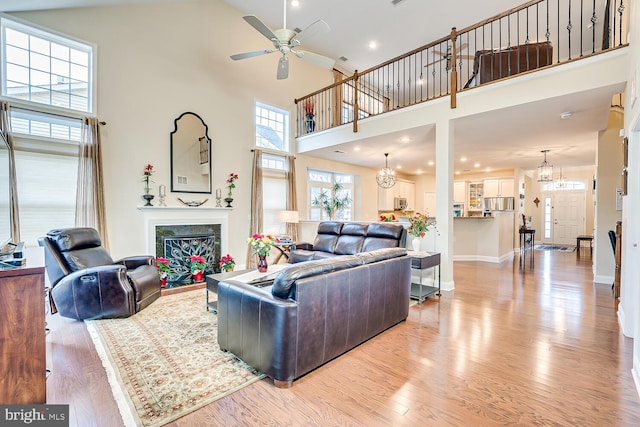 living room featuring ceiling fan, light wood-type flooring, and high vaulted ceiling