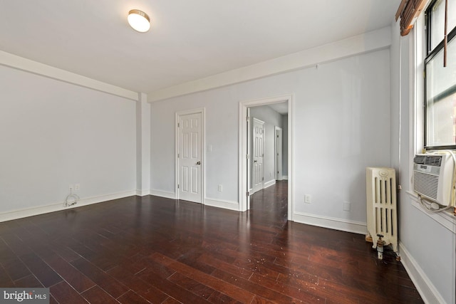 spare room with dark hardwood / wood-style floors and radiator