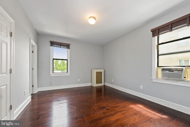 unfurnished room with cooling unit and dark hardwood / wood-style flooring