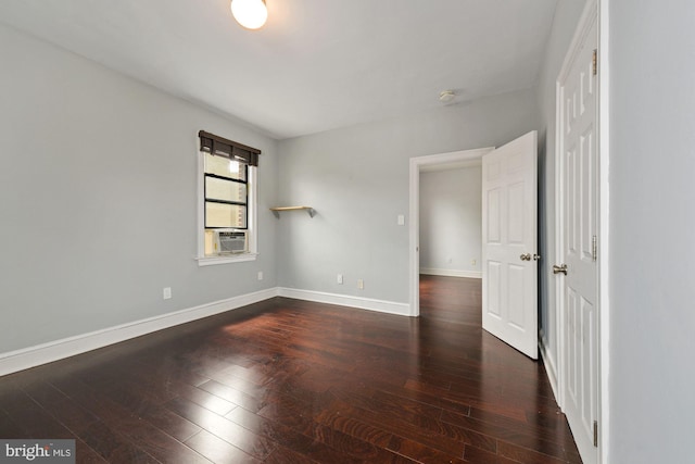 spare room with cooling unit and dark wood-type flooring