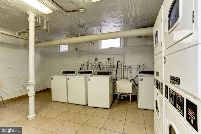 laundry area featuring washer and clothes dryer, light tile patterned flooring, sink, and stacked washer / dryer