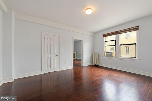 empty room featuring dark hardwood / wood-style floors, radiator, and cooling unit