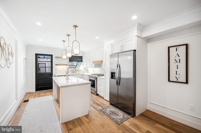 kitchen with light hardwood / wood-style flooring, decorative light fixtures, a kitchen island, white cabinetry, and stainless steel appliances