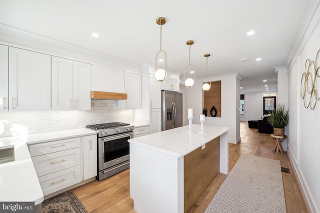 kitchen featuring white cabinetry, hanging light fixtures, a kitchen island, and stainless steel appliances