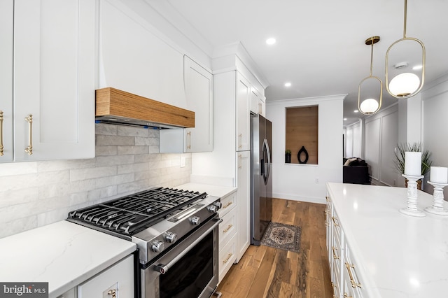 kitchen with light stone countertops, appliances with stainless steel finishes, dark hardwood / wood-style flooring, decorative light fixtures, and white cabinetry