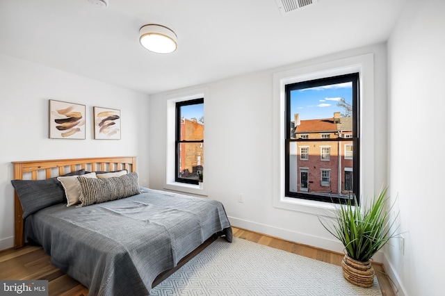 bedroom with light wood-type flooring and multiple windows