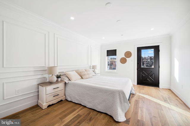 bedroom with light hardwood / wood-style floors and crown molding