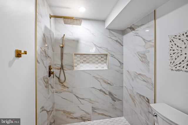 bathroom featuring tiled shower and toilet