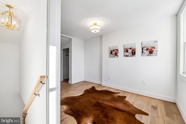 spare room with a chandelier and hardwood / wood-style flooring