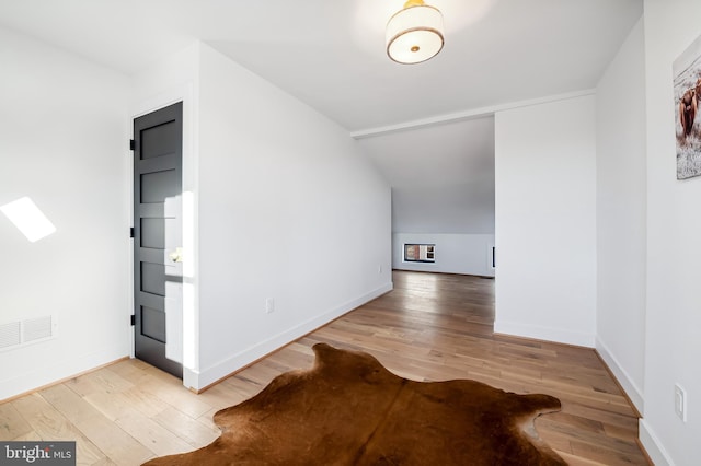 additional living space with vaulted ceiling and hardwood / wood-style flooring