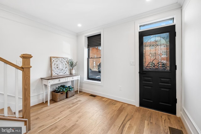 entrance foyer featuring light hardwood / wood-style flooring and ornamental molding