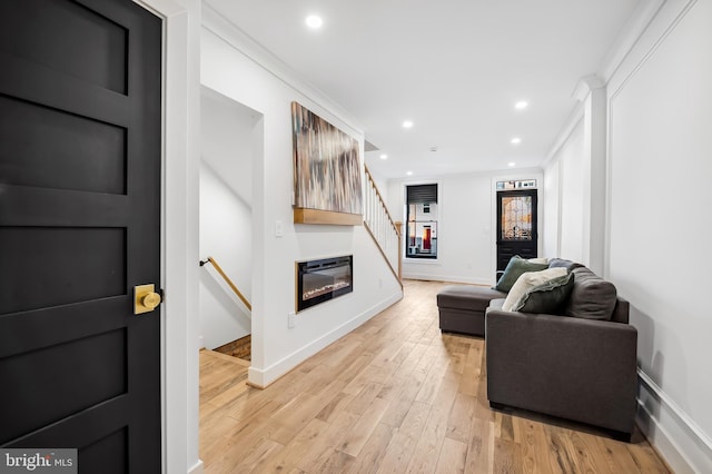 living room featuring light hardwood / wood-style floors and ornamental molding