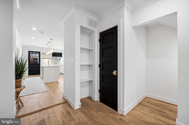 entryway featuring light hardwood / wood-style flooring and ornamental molding