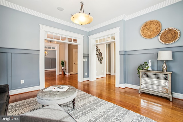 living area featuring hardwood / wood-style floors and ornamental molding