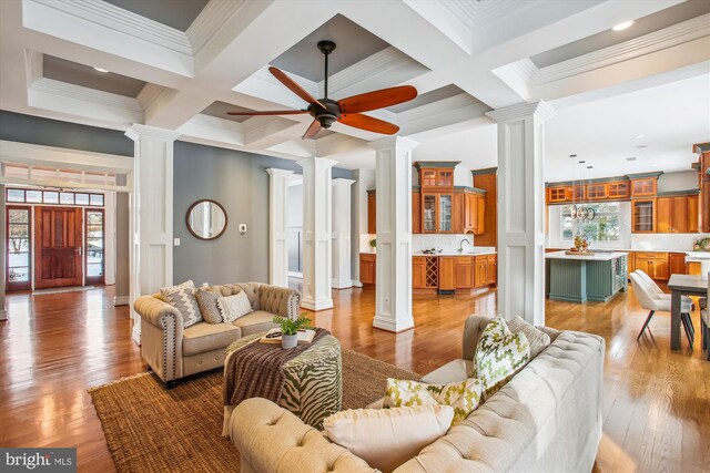 living room with decorative columns, a healthy amount of sunlight, and coffered ceiling