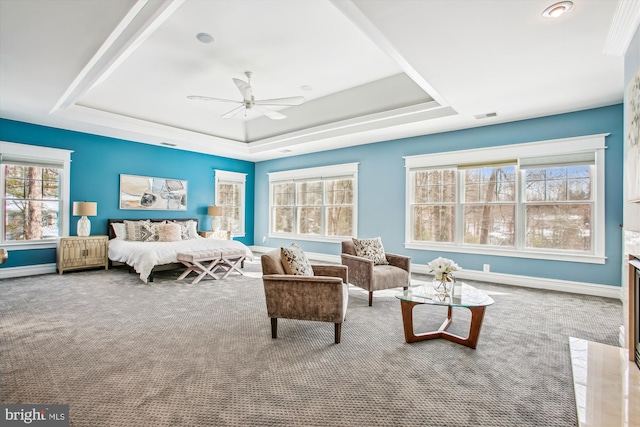 carpeted bedroom featuring ceiling fan and a tray ceiling