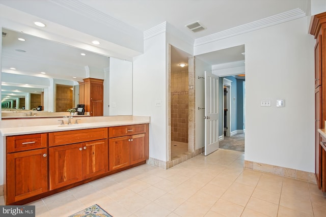 bathroom with tile patterned floors, vanity, ornamental molding, and tiled shower