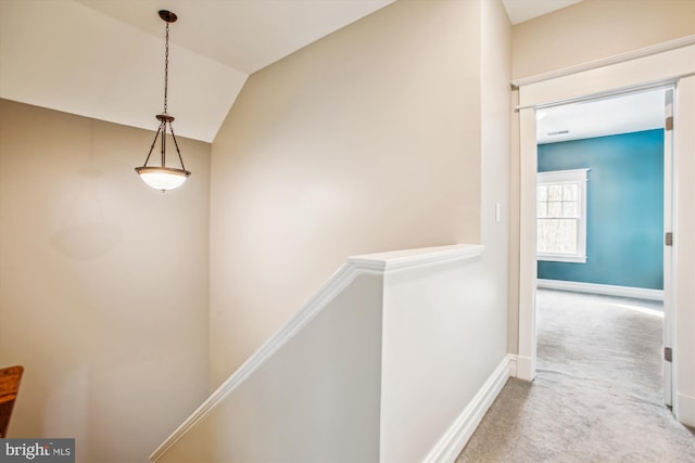 hallway with carpet and lofted ceiling