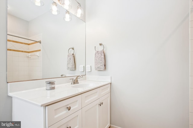 bathroom with a tile shower and vanity