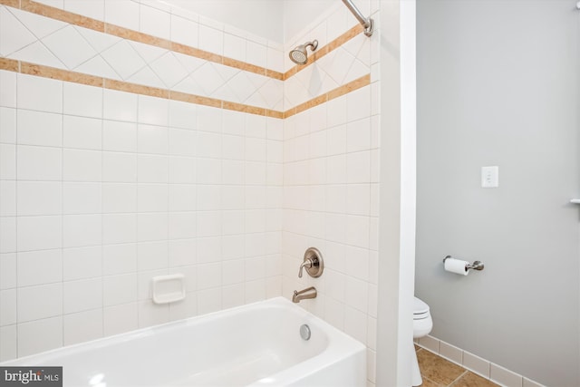 bathroom with tile patterned floors, toilet, and tiled shower / bath