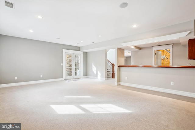 unfurnished living room with light colored carpet