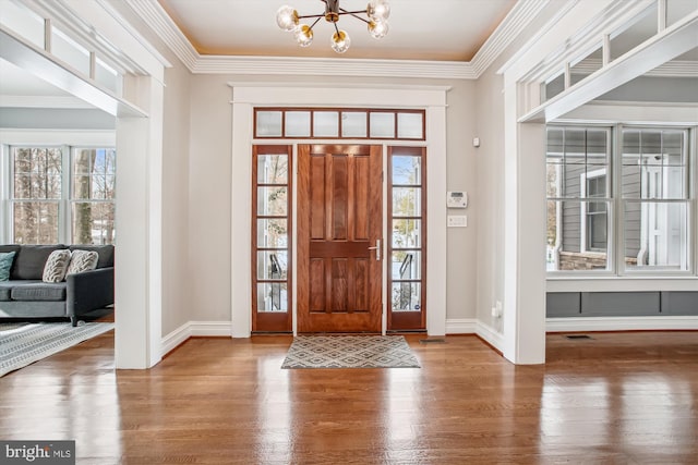 foyer with hardwood / wood-style flooring, a healthy amount of sunlight, and a notable chandelier