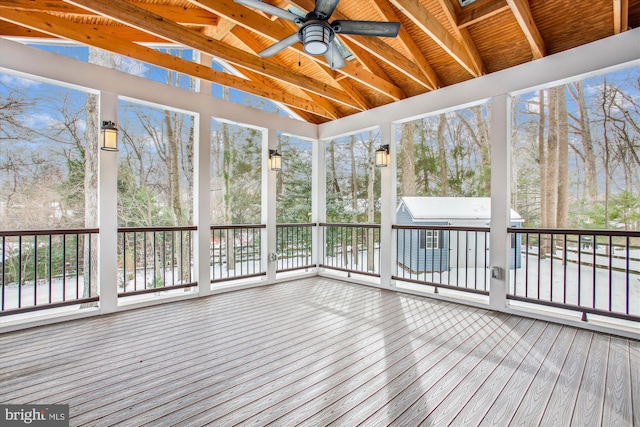 unfurnished sunroom featuring vaulted ceiling with beams, ceiling fan, and wooden ceiling