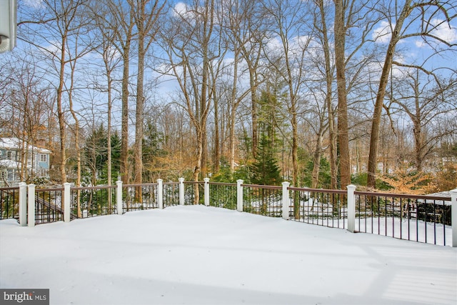 yard covered in snow featuring a deck