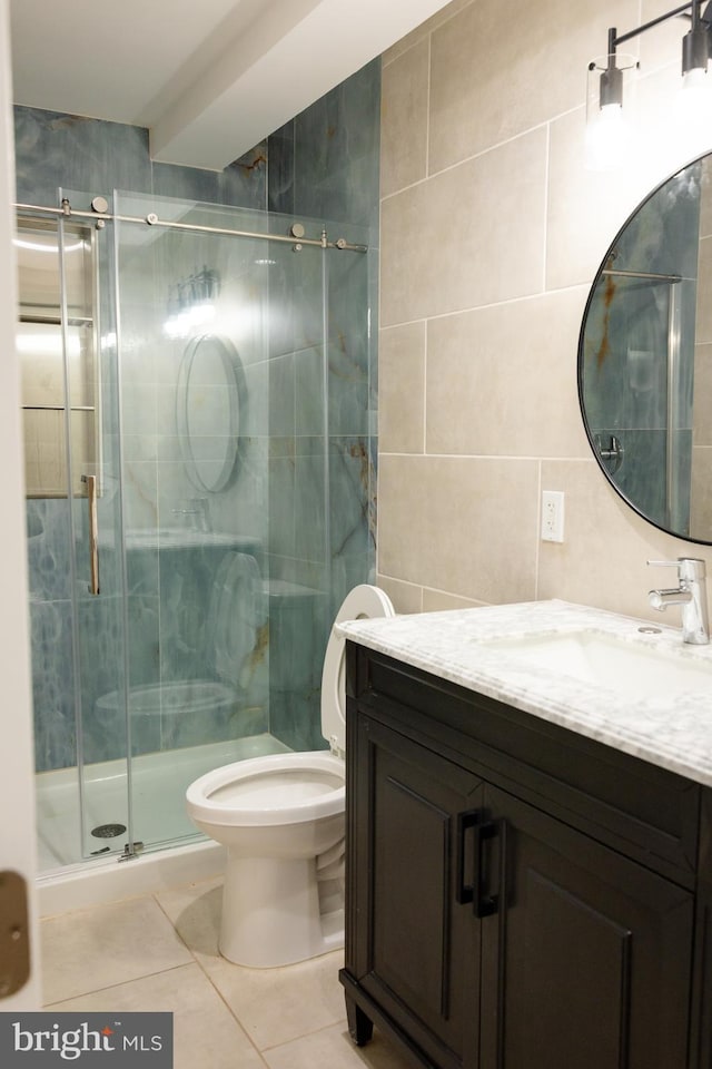 bathroom featuring vanity, tile patterned floors, toilet, tile walls, and an enclosed shower