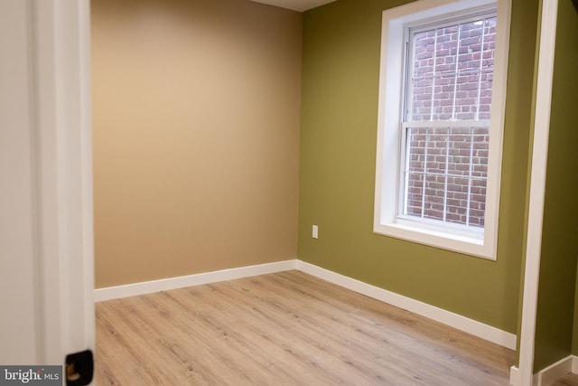 empty room with a wealth of natural light and light hardwood / wood-style floors